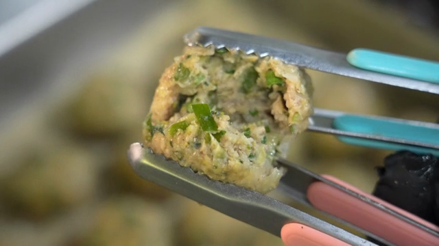 Slicing a rolling dumpling with tongs