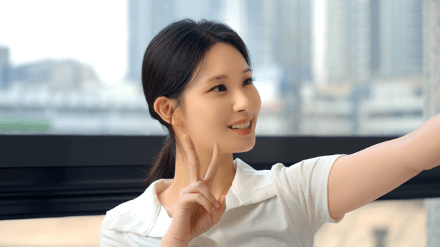 Profile of young woman posing with a V sign by the window