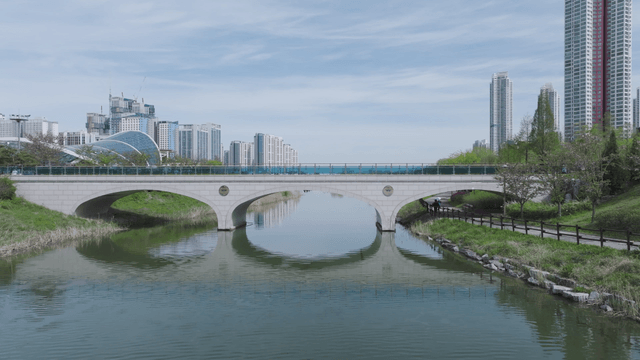Bridge connecting city buildings and lake park