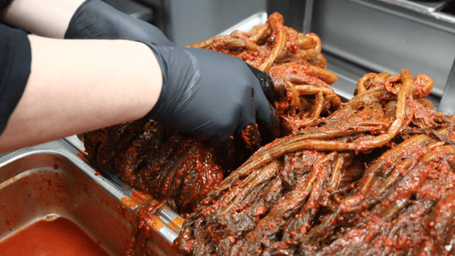 Gatgimchi being filled onto tray in kitchen