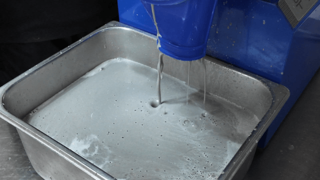 Black bean soy milk flowing from a soy maker