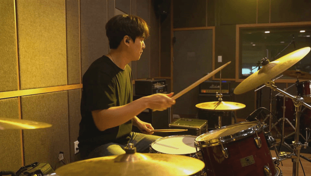 Drummer passionately playing drums in studio