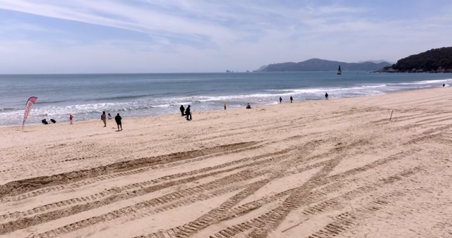 A sunny beach with people enjoying the sea