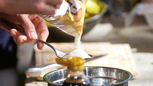 Sugar being measured into a bowl