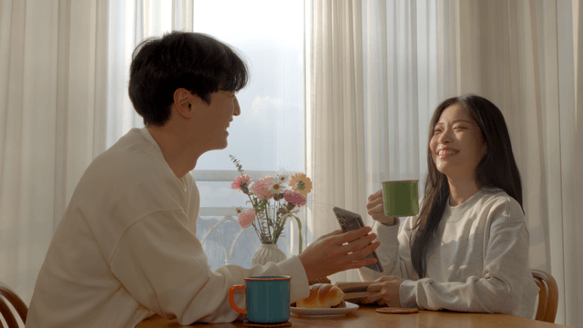 Couple smiling while looking at smartphone