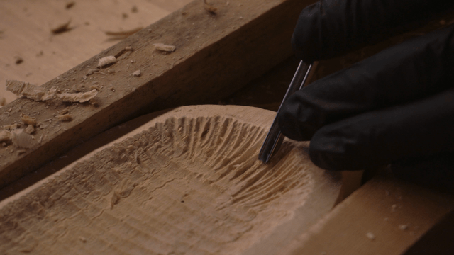 Hands of an artisan carving fine woodcraft