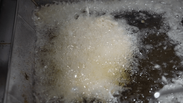Deep frying a breaded meat in hot oil