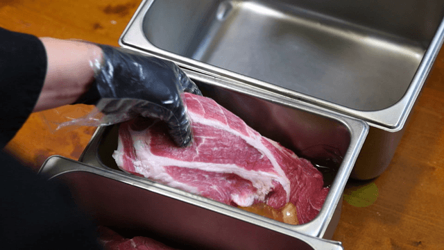 Chef dipping meat in avocado oil