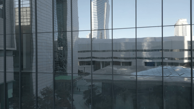 City building reflecting the urban skyline on glass exterior