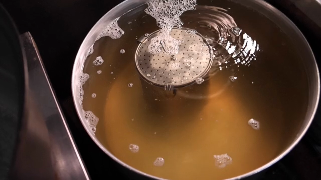 A pot of broth simmering on the stove