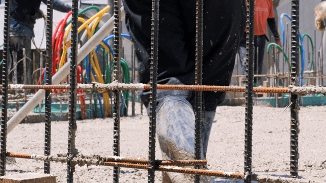 Worker smoothing wet concrete on a site
