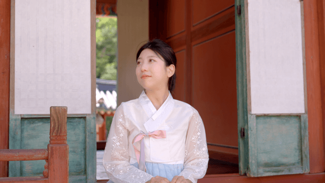 한옥에 앉아 있는 한복 입은 여성