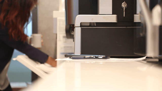 Office worker pouring water into a mug
