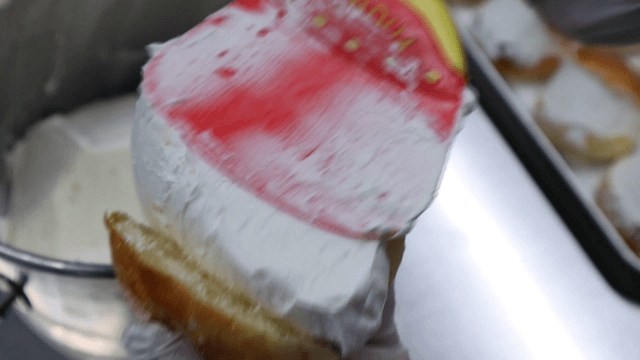 Cream being spread on a bun