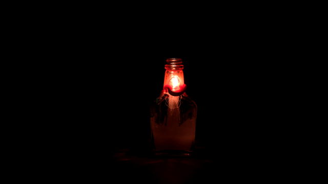Candle burning inside a glass bottle