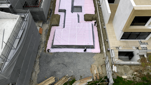 Workers laying insulation at a construction site