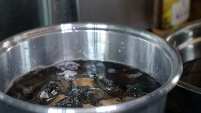 Water being poured into a pot with ingredients