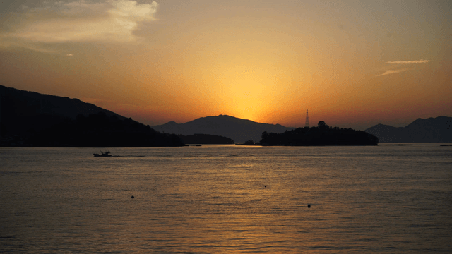 Sunset over a calm sea with mountains