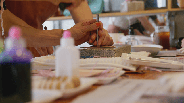 Hands working with a hammer on workshop table