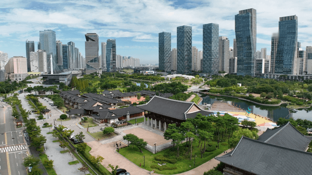 Traditional Korean house by the lake with skyscrapers in the background