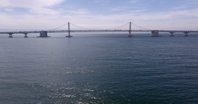A bridge over a calm sea under a clear sky