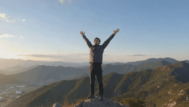 Man standing on a peak at sunrise