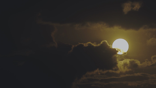 Sun setting behind dark clouds