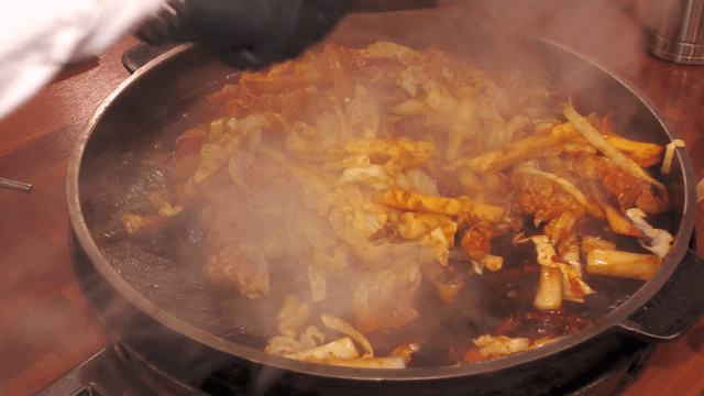 Stir-fried chicken being cooked in a pan