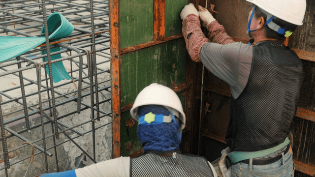 Workers fixing steel plates at construction site