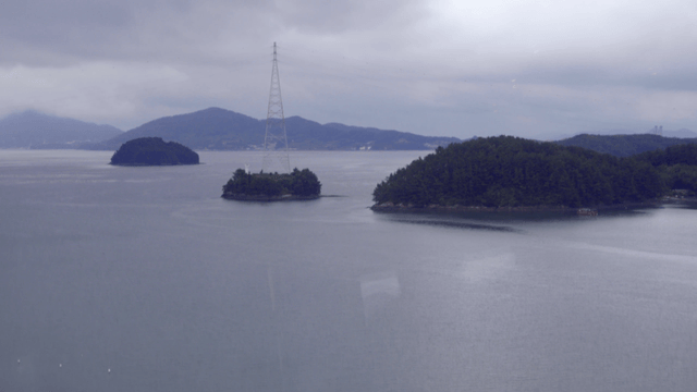 작은 섬과 흐린 하늘이 있는 잔잔한 바다