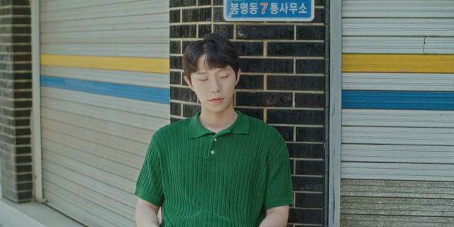 남자가 벽돌 벽에 기대어 있는 모습