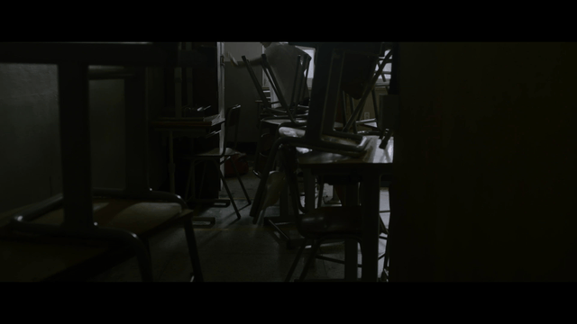 School violence in dark classroom with stacked chairs