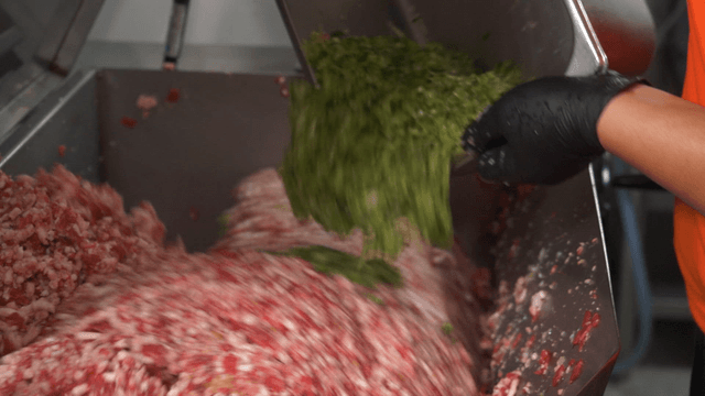 Commercial food mixer blending minced beef and vegetables