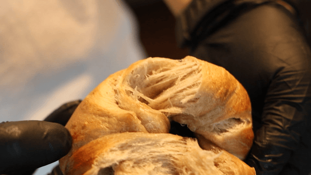 Hands tearing a freshly baked bread