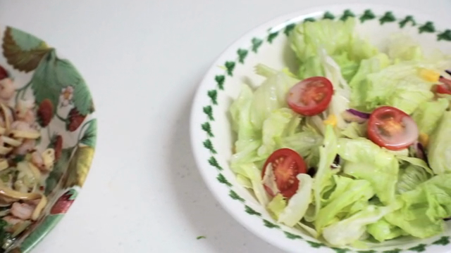 A bowl of shrimp pasta and a fresh salad