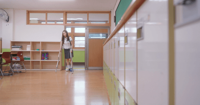 Student going to class on crutches in a classroom