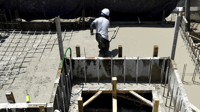 Worker smoothing concrete at a construction site