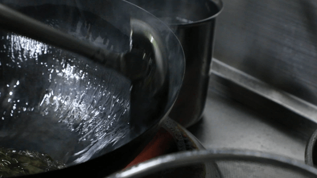 Flames rising from a wok in a kitchen