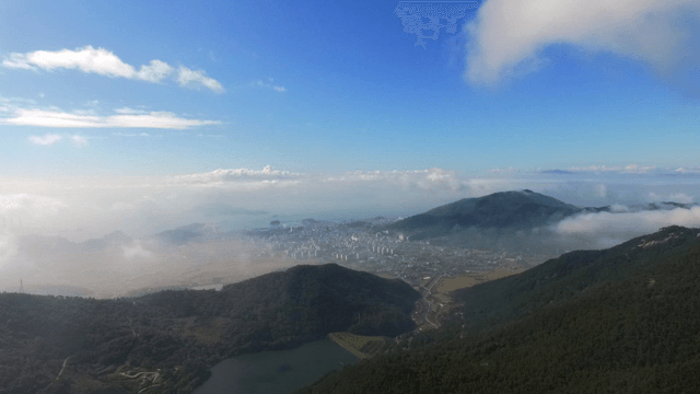 Cityscape surrounded by mountains and clouds