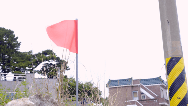 시골 전봇대 근처에서 흔들리는 빨간 깃발