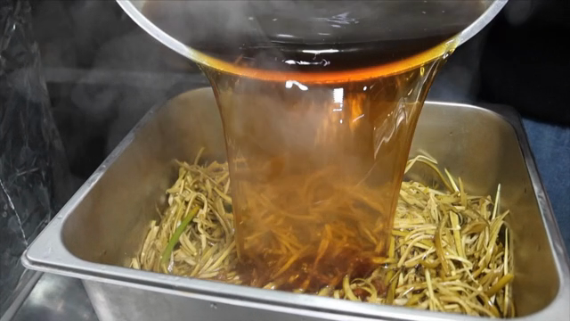 Pouring soy sauce over sliced vegetables