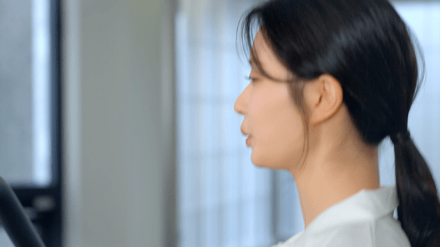 Side view of woman running on treadmill