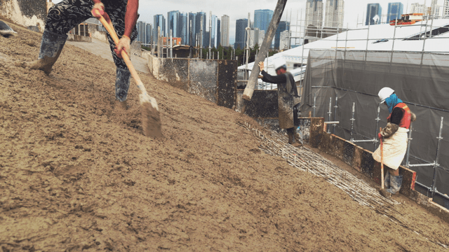 Workers pouring concrete at a construction site