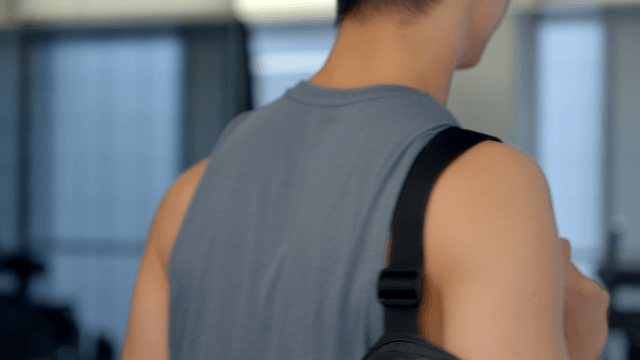 Young man entering gym shaking protein shake