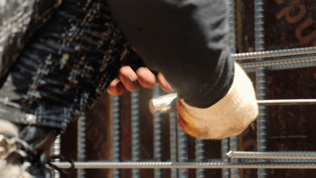 Worker tying rebar at a construction site