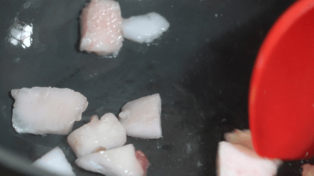 Ladle frying meat fat and oil in pan