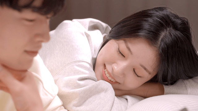 Smiling couple resting together on bed