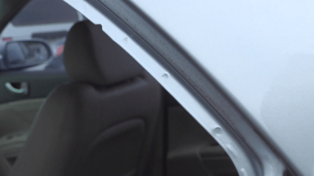 Hand adjusting rubber door seal on car