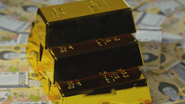 Gold bars stacked on Korean currency