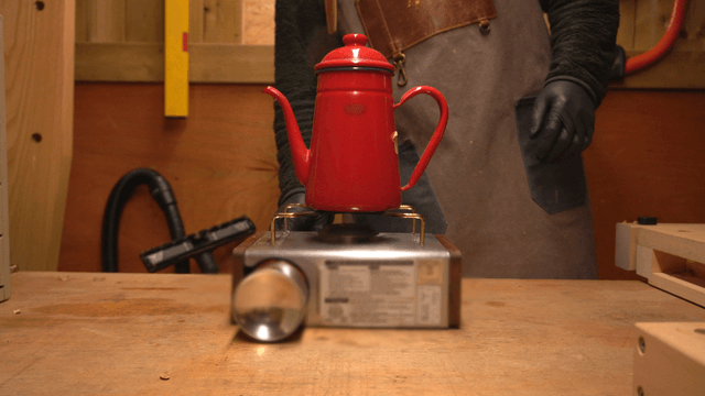 Red kettle boiling on a portable burner
